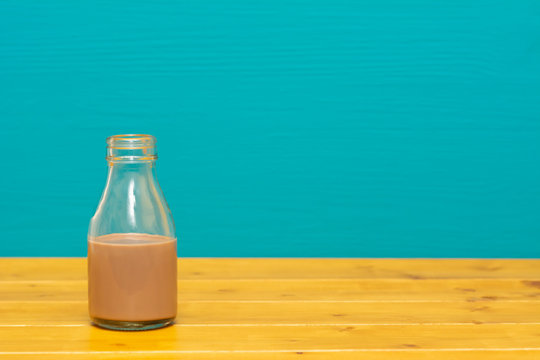 Glass Milk Bottle Half Full With Chocolate Milkshake