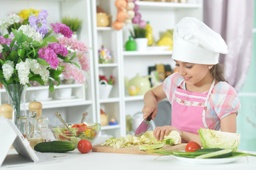 Portrait of cute little girl making dinner
