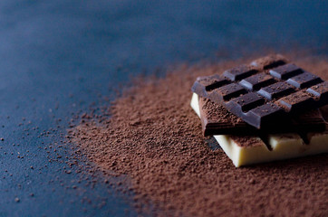 Flat with milk, black and white chocolate on a black background.