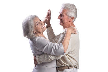Portrait of happy senior couple dancing on white background