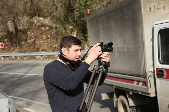 young man with video camera on the highway
