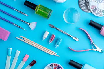 Set of cosmetic tools for professional manicure and nail care on blue background. Top view