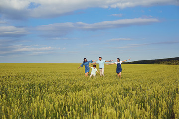 Happy family walking in summer field