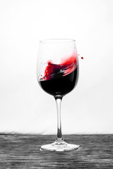 Red wine in the glass splashes in action on a white background. Stylish design card