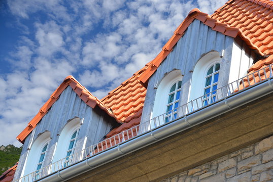 Neu renovierte Dachgauben mit Holzplanken-Verkleidung als Wetterschutz an einem denkmalgeschützten Wohngebäude