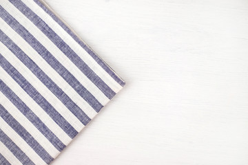 White wooden table with a blue striped tablecloth.