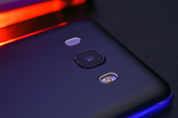 Close-up black phone case with creative blue and red backlight. Macro horizontal photography