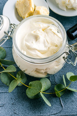 diy body butter with ingrdients on concrete background