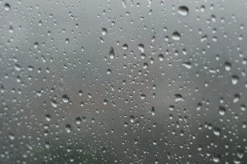 raindrops on glass window in grey background