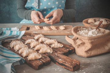 Female hands make dumplings. Cooking food from the dough.