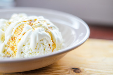 White cottage cheese with caramel. Dessert with cottage cheese, cream and caramel