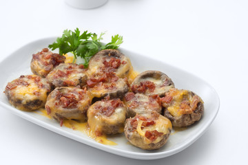 Cheese and bacon stuffed mushroom caps baked in the oven  on white background