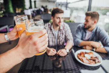 Focus on mans hands with a glass of beer