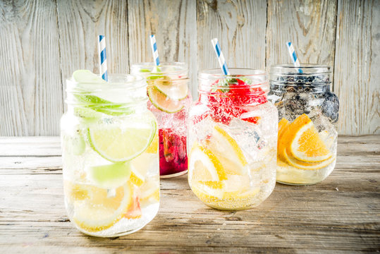Selection various fruit and berry lemonade drinks, refreshment infused water, in mason jars, with fresh strawberry, lemon, lime, oranges, blueberry,  copy space