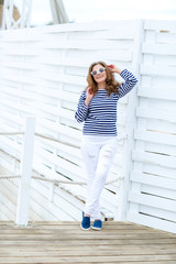 curly woman on a white background in a stylish white jeans.