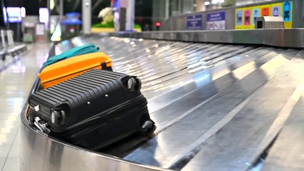 Various suitcases on conveyor belt in the international airport - Powered by Adobe