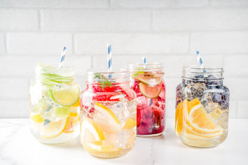 Selection various fruit and berry lemonade drinks, refreshment infused water, in mason jars, with fresh strawberry, lemon, lime, oranges, blueberry,  copy space