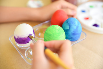 Fototapeta na wymiar Happy Easter Day. Easter eggs concept. A girl hand painting Easter eggs. Happy family preparing for Easter.