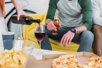 cropped view of man and woman near table with drinks and snacks