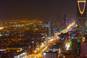 Panorama view to the skyline of Riyadh by night, with the Kingdom centre in the background and yellow lighting, the capital of Saudi Arabia