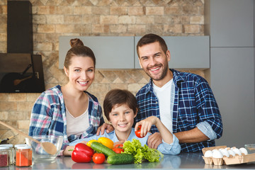 Family at home standing in kitchen together hugging looking camera cheerful