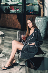 Fototapeta na wymiar Beautiful woman relaxing in bathrobe in spa center