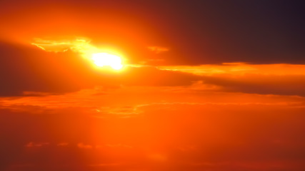 Defocused image of an orange sunrise in the clouds.