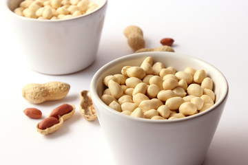 raw peeled peanuts on a light background
