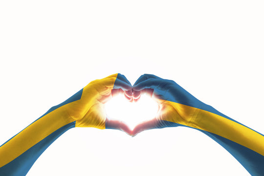 Sweden flag on people heart   shape hands.