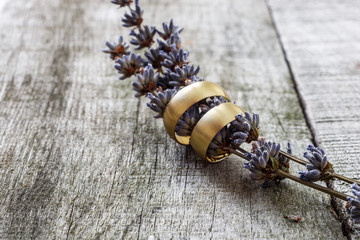 Wedding rings and lavender flower on wooden background