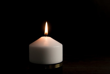 Obraz na płótnie Canvas White candle with black ribbon, symbol of remembrance or mourning, black background. Lot of blank copy space for your text. In memoriam.