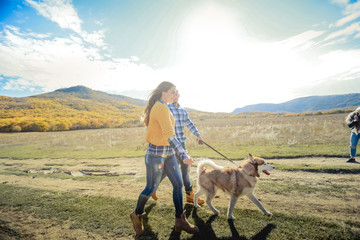 Couple walk retriever dog autumn sunset countryside meadow holding hands