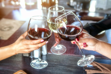 happy friends in a bar drinking red wine.