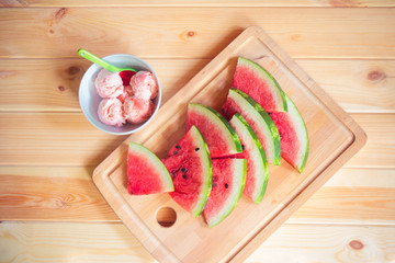 Watermelon  ice cream in bowl and slices of watermelon near on wooden table. Top view.