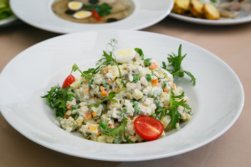 Traditional Russian Christmas Salad Olivier on a white plate