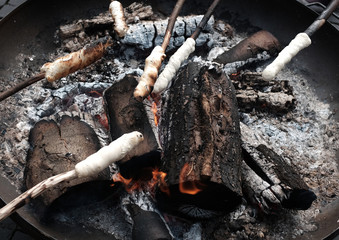 Aufgespießtes Stockbrot über glühender Kohle