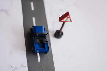 miniature of a car in front of a road sign