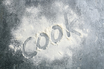 Handwritten word cook on grey stone background