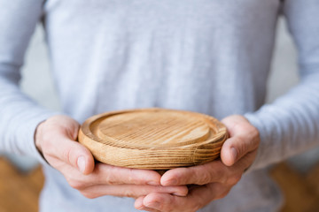 Nature protection concept. Wooden tray mockup in man hands. Free space for advertising.