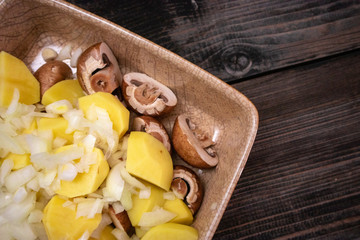 Simply, fast and tasty vegetarian dish from potato, brown champignon mushroom and onion with spices, ready for baking.