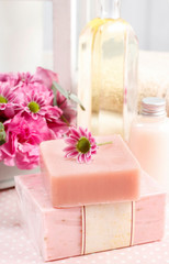 Fototapeta na wymiar Two bars of pink soap and cute little flower.