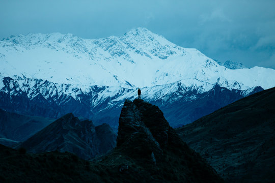 Person Standing On Mountain Peak During Winter