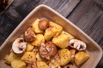 Simply, fast and tasty vegetarian dish from potato, brown champignon mushroom and onion with spices, ready for baking.