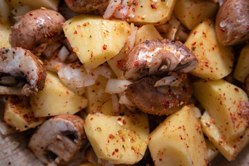 Simply, fast and tasty vegetarian dish from potato, brown champignon mushroom and onion with spices, ready for baking.