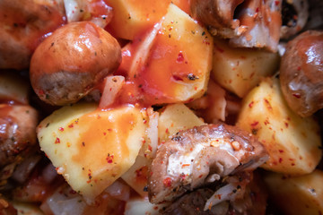 Simply, fast and tasty vegetarian dish from potato, brown champignon mushroom and onion with spices, ready for baking.