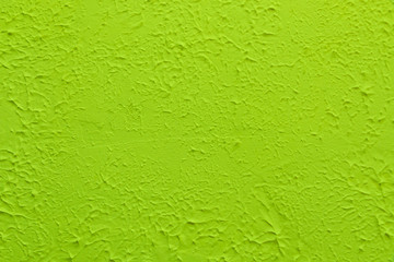 Green textured wall. Decorative plastering close-up photo. Surface with stucco daub