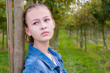 young girl in denim jacket outdoors, closeup portrait