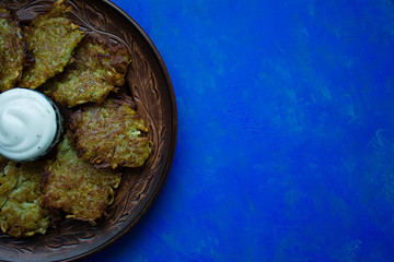 Potato fritters with sauce on a blue background. View from above