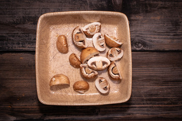 Sliced brown champignon mushrooms in a ceramic bowl