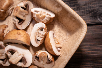 Fototapeta na wymiar Sliced brown champignon mushrooms in a ceramic bowl